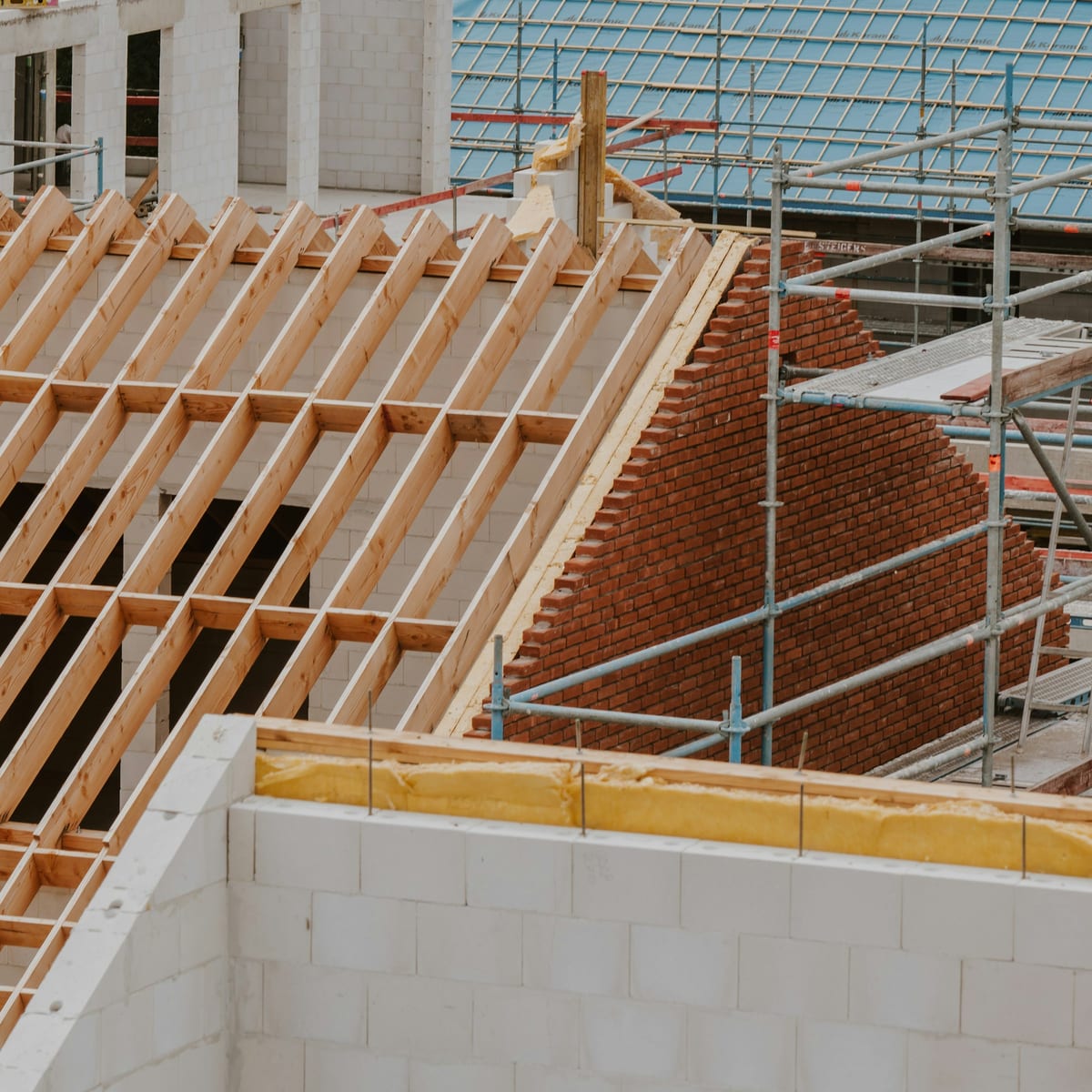 Neuer Dachstuhl aus Holz mit Gerüst auf einer Baustelle